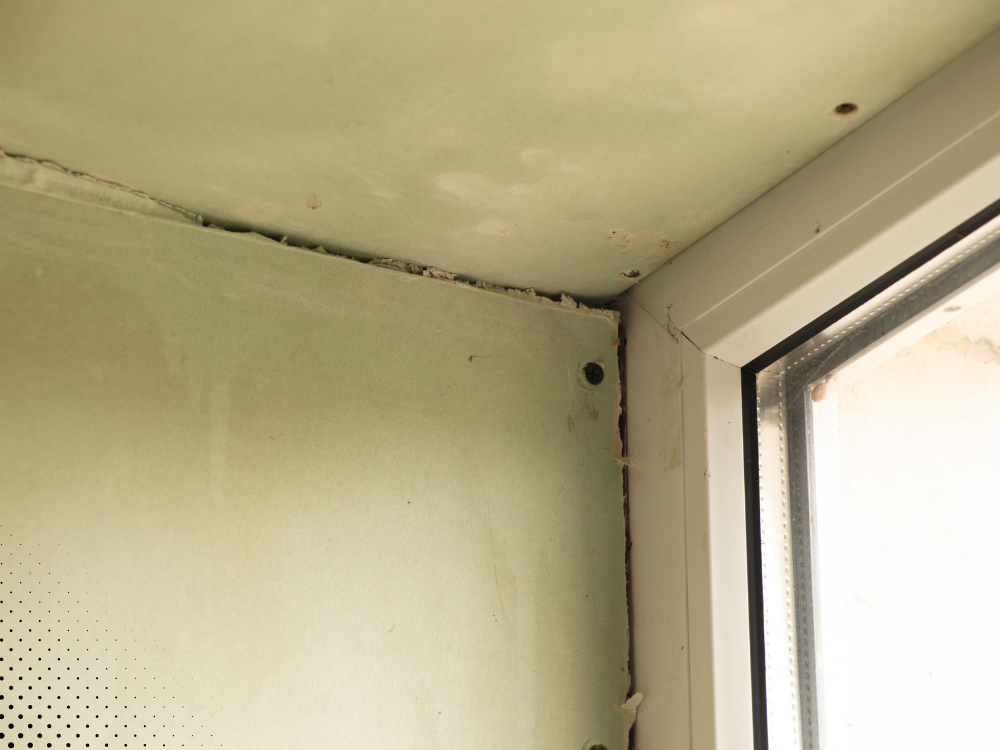 Water damage on the drywall around the window corner.